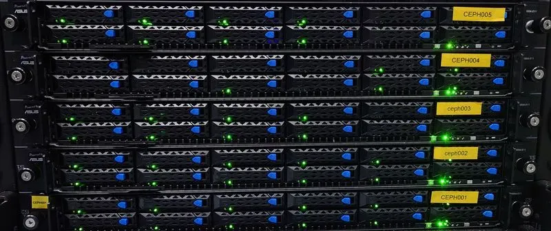 Server-Racks mit aktiven, grün beleuchteten Statusanzeigen und Beschriftungen in einem Rechenzentrum. Die Serverfronten zeigen blaue und gelbe Markierungen, die die verschiedenen Einheiten kennzeichnen